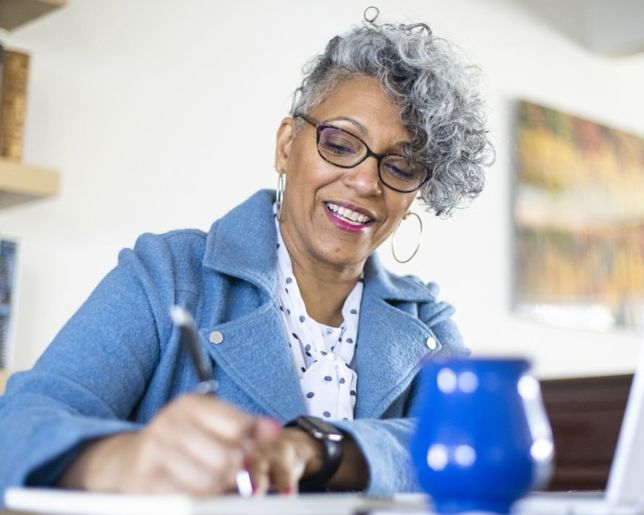Professional woman taking notes while sitting at a table