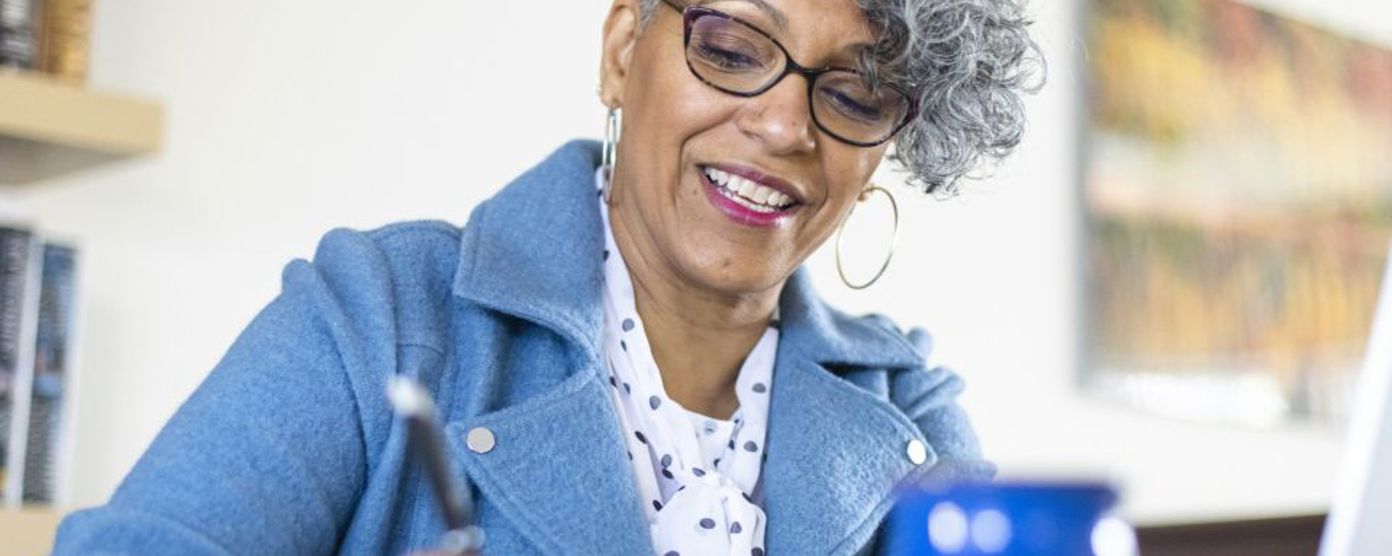 Professional woman taking notes while sitting at a table