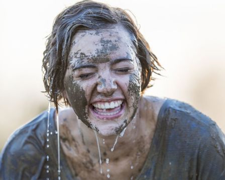 Woman laughing as she is wet doing a mud run