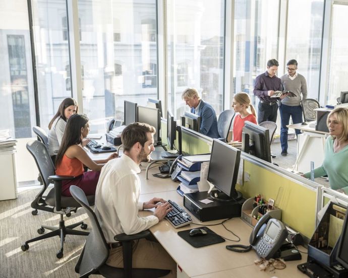 group of employees sitting on a bank working