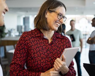 Professional woman holding a laptop and smiling