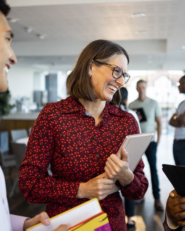 Professional woman holding a laptop and smiling