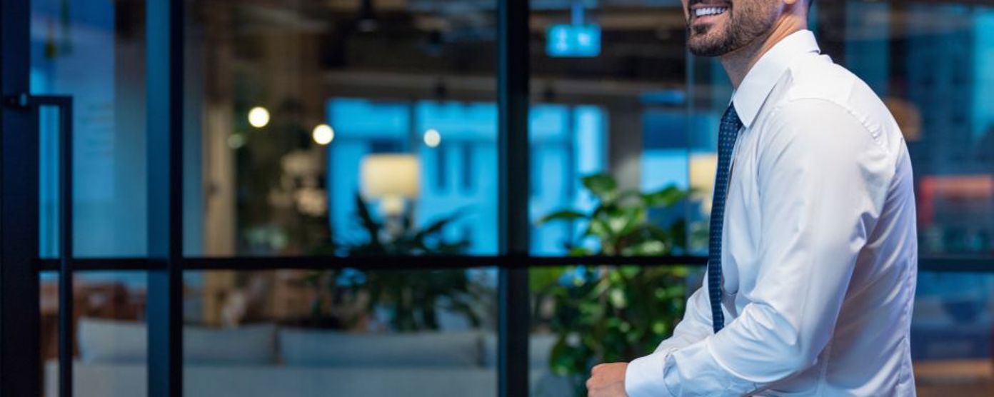 Man in a suit sitting on the side of a table