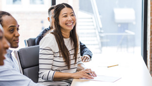 smiling-adults-in-a-row-sitting-at-desks.jpg