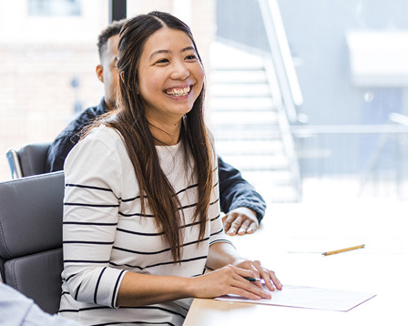 smiling-adults-in-a-row-sitting-at-desks.jpg
